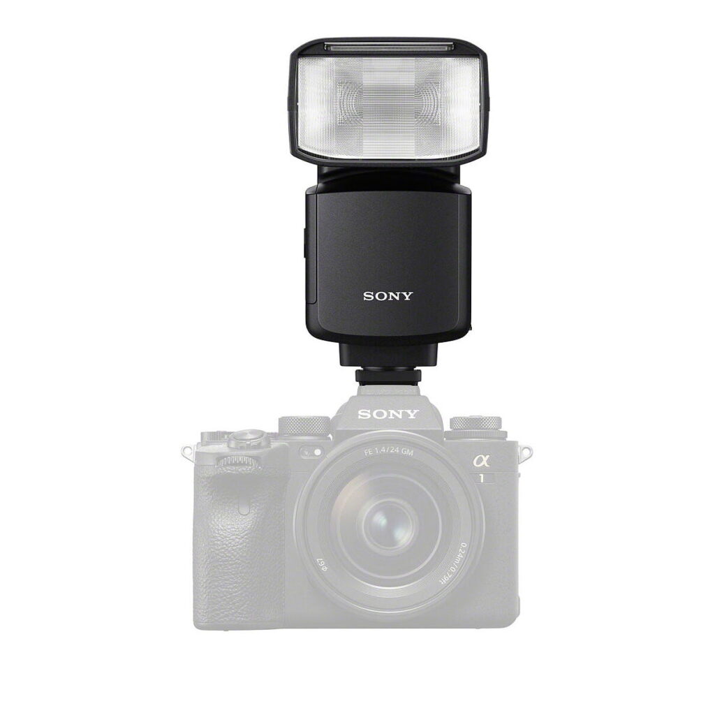 Musta Sony HVL-F60RM2 -salama on asennettu osittain läpinäkyvän Sony Alpha -peilittömän kameran ja objektiivin päälle valkoista taustaa vasten.