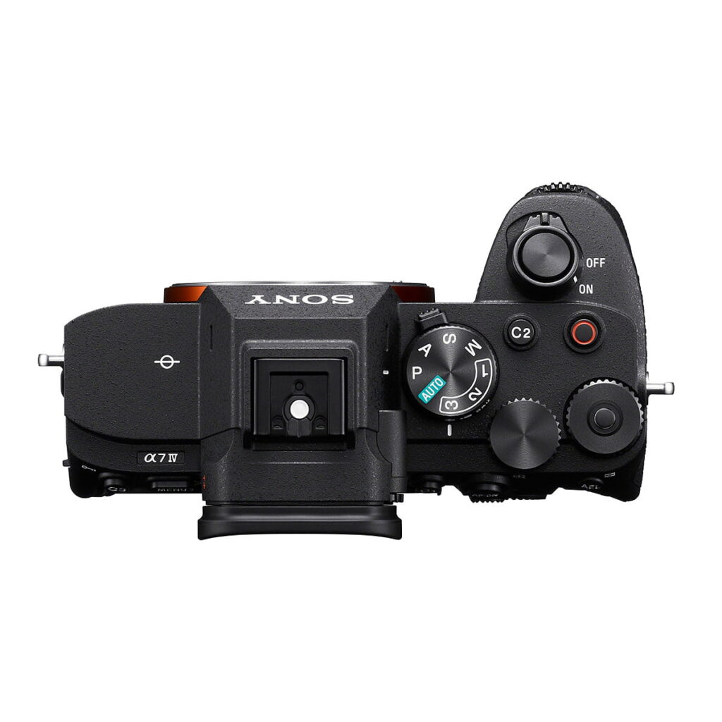 Sony_a7_IV_002 Ylhäältä katsottuna Sony A7 IV -järjestelmäkamera (300€ alennus), jossa on ohjauspyörät, virtakytkin, moodivalitsin, kuumakenkäkiinnitys ja useita painikkeita tyylikkäässä mustassa rungossa.