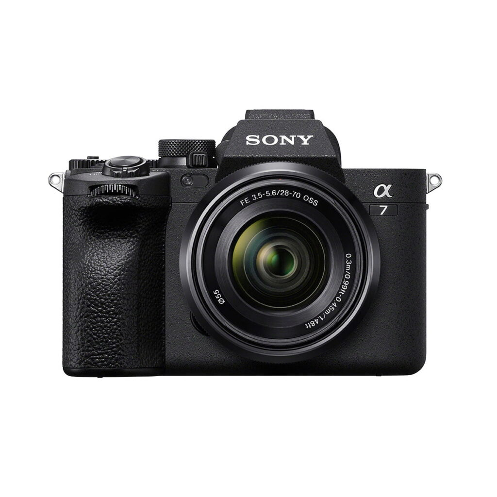 Sony_a7_IV_28-70mm_001 Etukuva mustasta Sony A7 IV -digitaalisesta peilittömästä kamerasta ja 28-70mm f/3.5-5.6 OSS-objektiivista, jossa on kuvioitu kahva ja objektiivin merkinnät valkoista taustaa vasten.