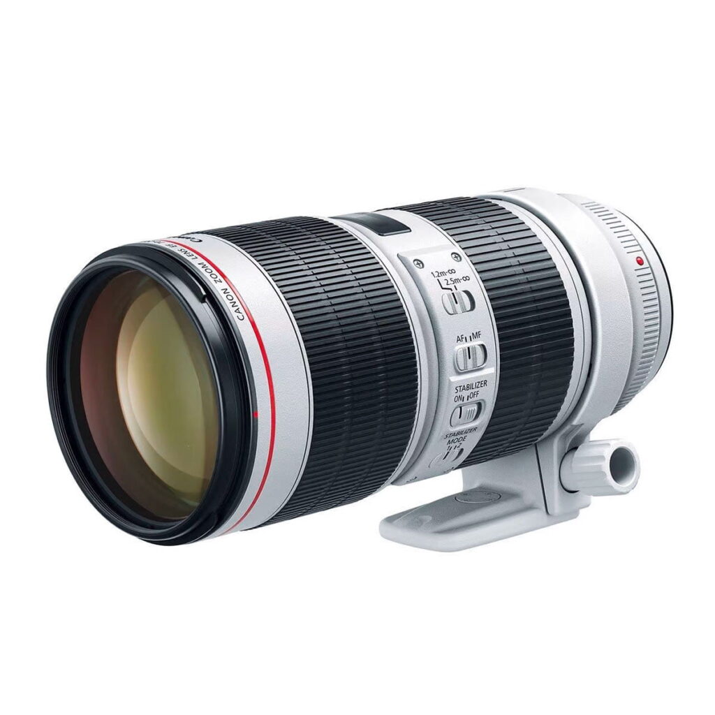 canon_70-200_is_III Canon EF 70-200mm f/2.8L IS III USM on valkoinen teleobjektiivi, jossa on punainen rengas, musta kahva, useita säätökytkimiä ja jalustakiinnitysrengas valkoisella pohjalla.