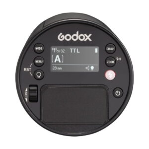 godox_ad100_pro_ttl_03 Yläkuvassa pyöreä Godox AD100 Pro TTL -akkusalama-salaman ohjausyksikkö, jossa on näyttö, painikkeita, valintakiekko ja merkittyjä ohjaimia tilalle, zoomille, valikolle ja virralle.