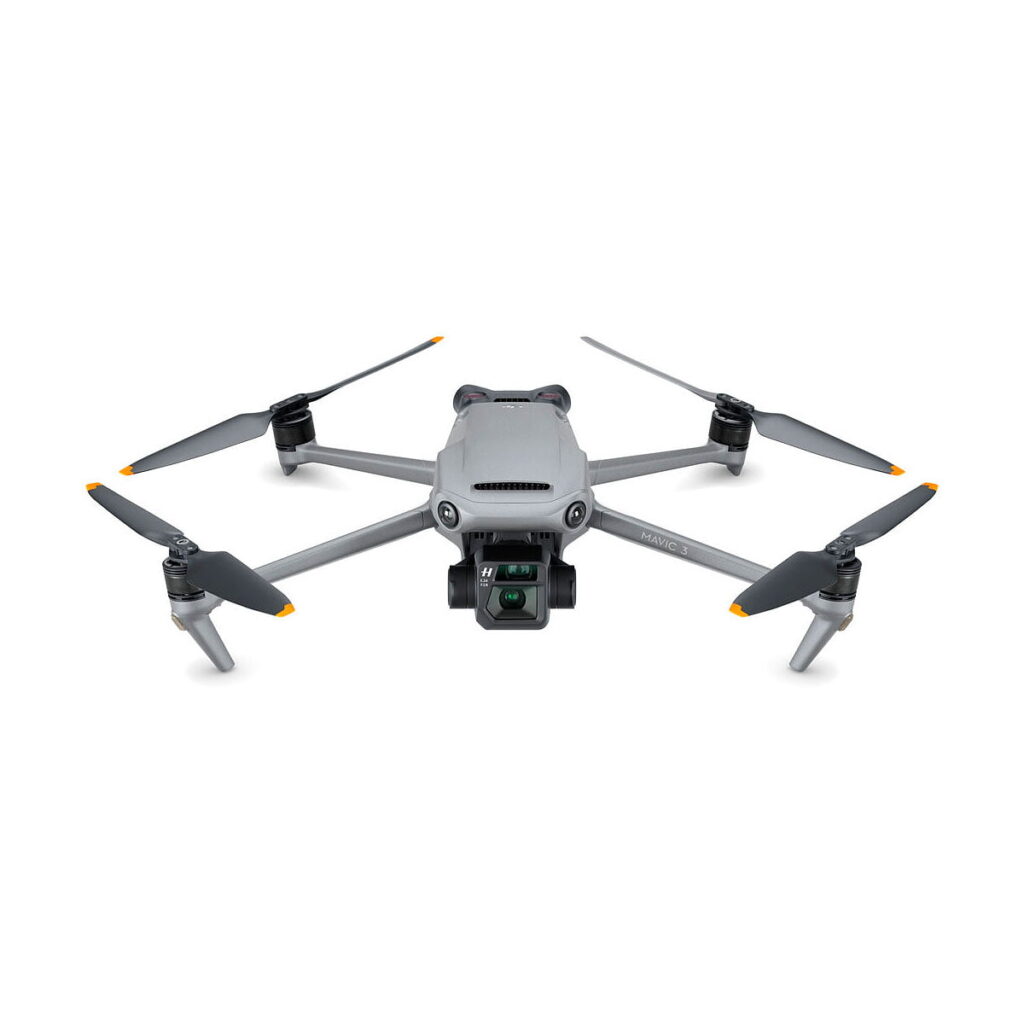 DJI_Mavic_3_Fly_More_Combo_001 DJI Mavic 3 Fly More Combo -lennokki on harmaa nelikopteri, jossa on neljä potkuria, oranssilla korostetut kärjet ja etukamera valkoisella pohjalla.