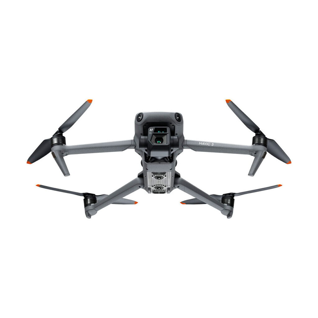 DJI_Mavic_3_Fly_More_Combo_007 DJI Mavic 3 Fly More Combo -lennokki on harmaa, ja siinä on neljä oranssilla kärjellä varustettua potkuria ja etukamera valkoista taustaa vasten.