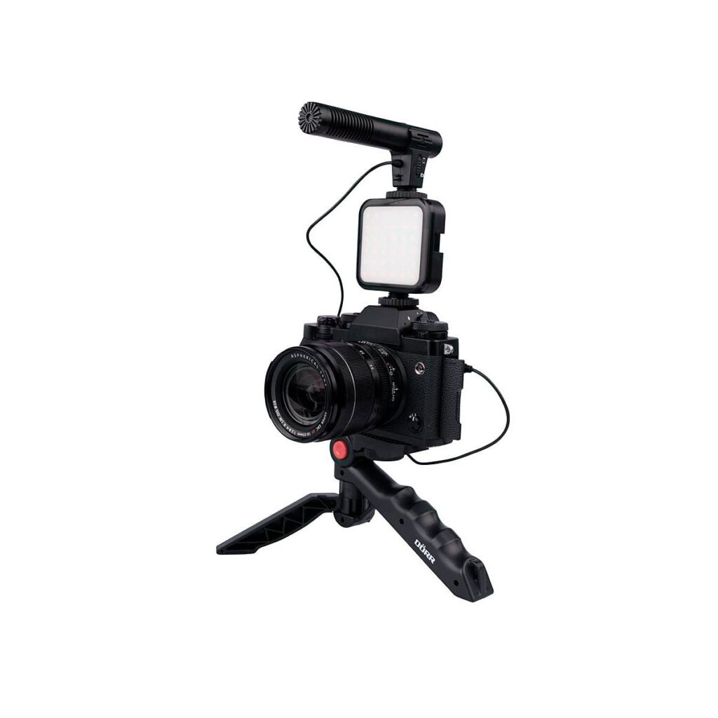 Dörr_VL-5_Vlogging_Kit_Mikrofonilla_007 Dörr VL-5 Vlogging Kit Mikrofonilla, joka sisältää kompaktilla jalustalla olevan digitaalikameran, johon on kiinnitetty ulkoinen mikrofoni ja LED-valo, on asennettu vloggausta tai videokuvausta varten valkoista taustaa vasten.
