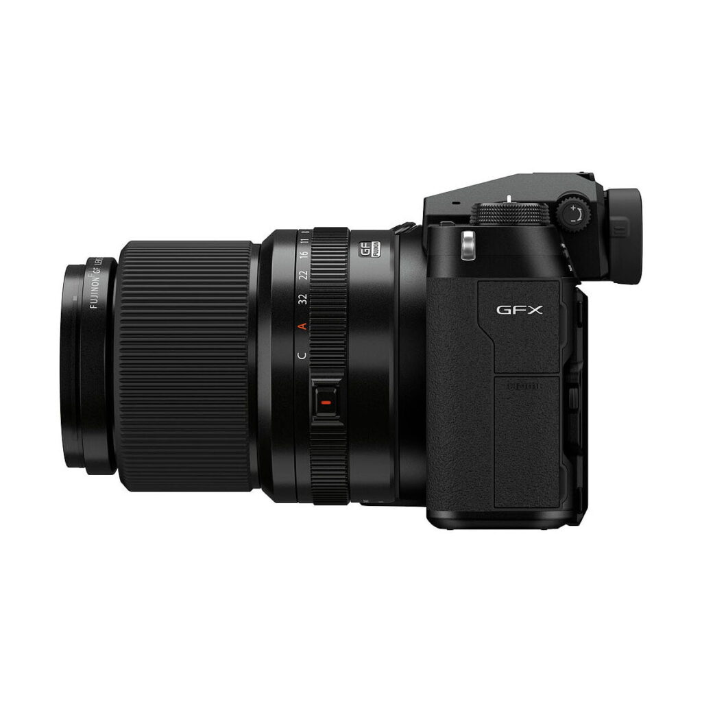 Fujifilm_GFX_100S_012 Sivunäkymä mustasta Fujifilm GFX 100S -järjestelmäkamerasta esittelee sen kiinnitetyn zoom-objektiivin, näkyvät säätöpyörät ja kuvioidun kahvan.