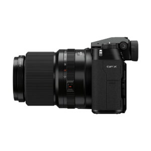 Fujifilm_GFX_100S_012 Sivunäkymä mustasta Fujifilm GFX 100S -järjestelmäkamerasta esittelee sen kiinnitetyn zoom-objektiivin, näkyvät säätöpyörät ja kuvioidun kahvan.