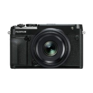 Fujifilm_GFX_50R_005 Mustan Fujifilm GFX 50R -digitaalikameran etukuva, jossa on kuvioitu kahva ja suuri objektiivi, keskitetty valkoiselle taustalle.