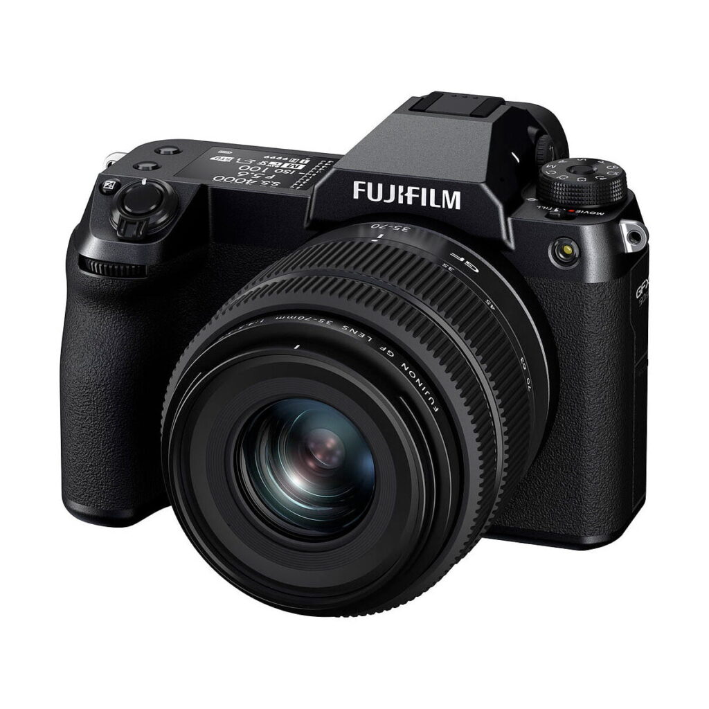 Fujifilm GFX 50S II, musta digitaalikamera, jossa on suuri irrotettava objektiivi ja useita säätöpyörästöjä, on kuvattu kolmivartalokulmasta valkoisella taustalla.