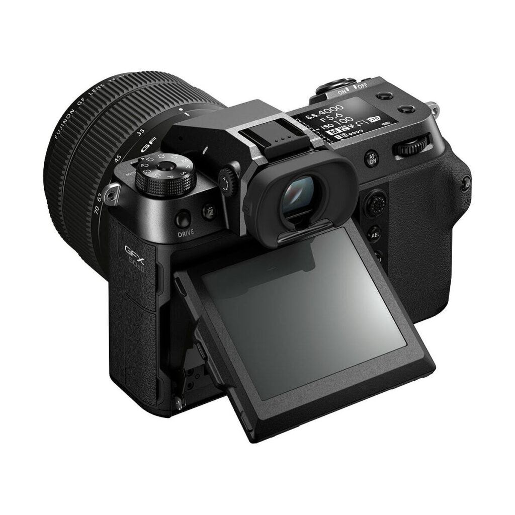 Fujifilm GFX 50S II, musta digitaalikamera, jossa on suuri objektiivi ja kallistettava LCD-näyttö, näkyy valkoisella taustalla. Ulospäin kallistettu näyttö osoittaa sen joustavuutta eri kuvauskulmia varten.