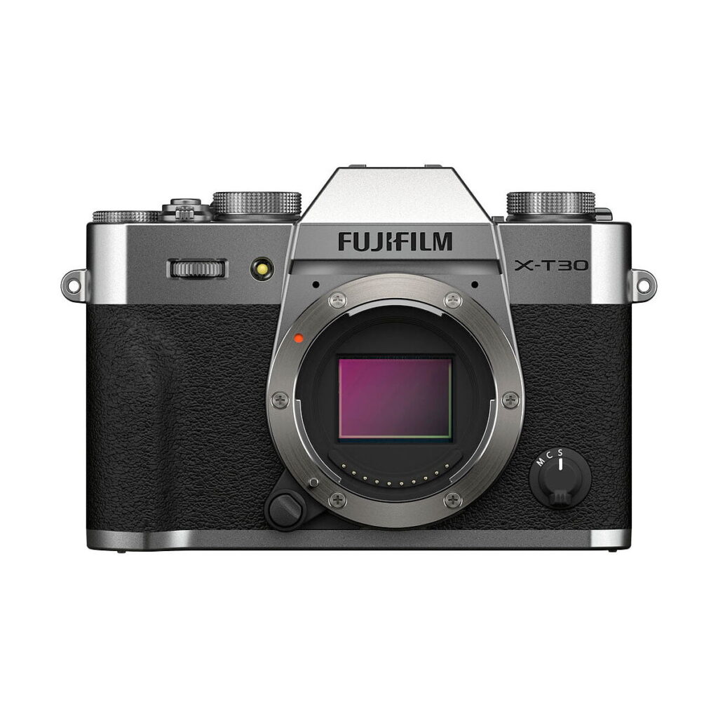 Fujifilm_X-T30_II__Hopea_001 Fujifilm X-T30 II Hopea -peilittömän kameran etukuva hopeanvärisenä ja mustana, jossa näkyy objektiivin kiinnitys ilman kiinnitettyä objektiivia ja merkin logo kennon yläpuolella.