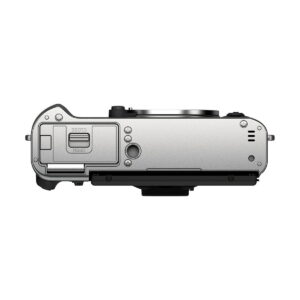 Fujifilm_X-T30_II__Hopea_004 Fujifilm X-T30 II Hopea hopeanvärisen digitaalikameran rungon ylhäältä, jossa näkyy akkulokeron luukku, säätimet, painikkeet, objektiivin kiinnitys ja portit. Kamera on asetettu valkoista taustaa vasten.