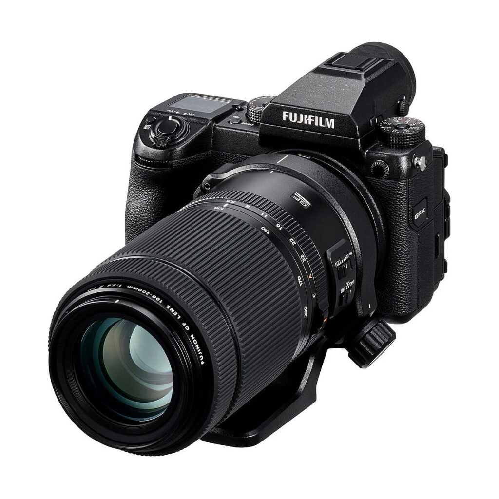 Fujinon_100-200mm_f_5_6_Macro_R_LM_OIS_WR_005 Fujifilm Fujinon GF 100-200mm f/5.6 R LM OIS WR -objektiivi näkyy kiinnitettynä kameraan kulmassa, jolloin painikkeet, kahva ja objektiivin kiinnitys korostuvat valkoista taustaa vasten. Nyt 500€ alennuksella.
