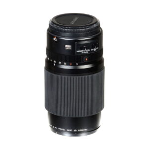 Fujifilm Fujinon GF 120mm f/4 Macro R LM OIS WR -objektiivi mustana, jossa on kuvioitu tarkennusrengas, aukon merkinnät ja objektiivin suojus, seisoo pystyssä valkoisella taustalla.