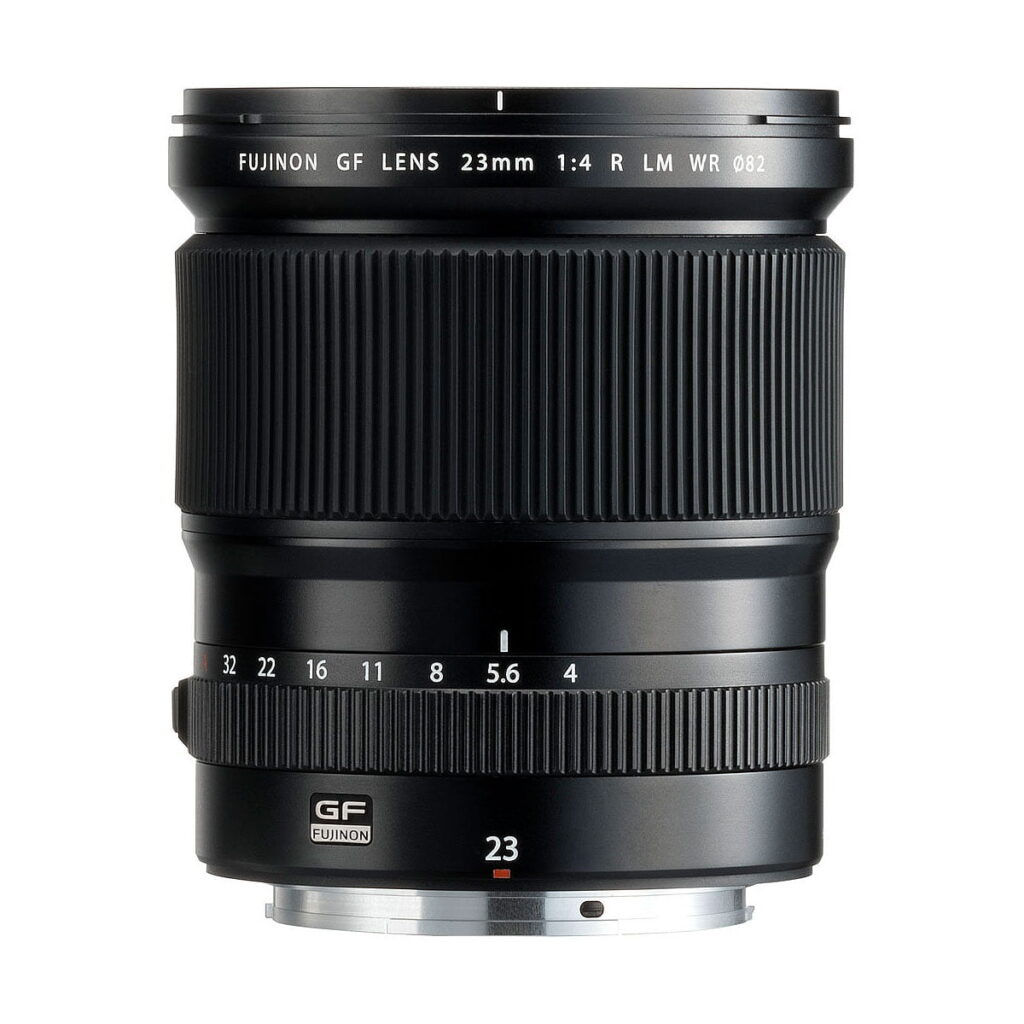 Fujinon_GF_23mm_f_4_R_WR_001 The Fujifilm Fujino GF 23mm f/4 R LM WR lens stands upright against a white background, showing its wide focus ring, aperture markings and metal lens mount.