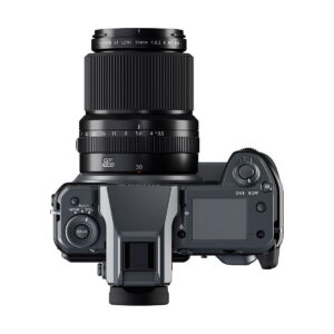 Ylhäältä katsottuna musta Fujifilm-digitaalikamera, johon on asennettu Fujifilm Fujinon GF 30mm f/3.5 R WR -objektiivi, jossa näkyy säätimiä, painikkeita ja LCD-näyttö valkoista taustaa vasten.