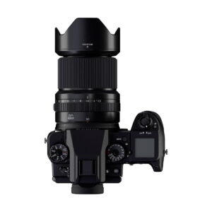 Ylhäältä katsottuna musta Fujifilm-kamera, jossa on Fujinon GF 30mm f/3.5 R WR -objektiivi, jossa on suuri objektiivi ja huppu, näkyvät säätöpyörät, painikkeet ja LCD-näyttö oikealla puolella.