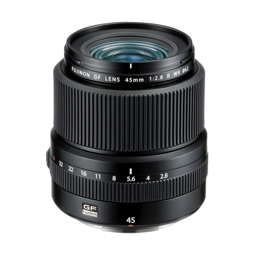 Fujinon_GF_45mm_2_8_R_WR_001 A Fujifilm Fujinon GF 45mm f/2.8 R WR -objektiivi, musta, selkeine tarkennus- ja aukon säätörenkaineen sekä näkyvine linssielementteineen, seisoo pystyssä valkoista taustaa vasten.