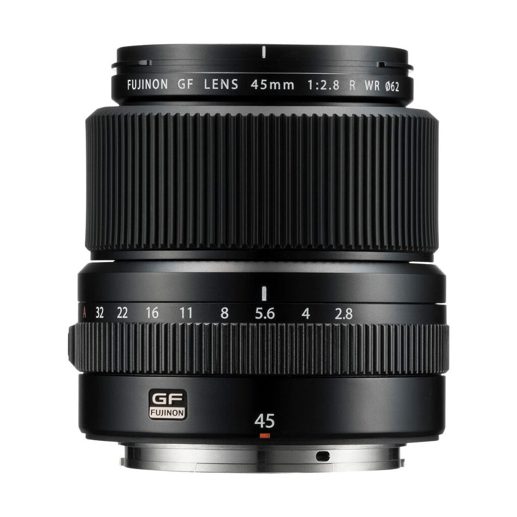 Fujinon_GF_45mm_2_8_R_WR_002 Fujifilm Fujinon GF 45mm f/2.8 R WR -objektiivin lähikuvassa näkyvät sen tarkennusrenkaat, aukkorenkaat, objektiivin merkinnät ja tuotemerkki valkoista taustaa vasten.