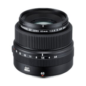Fujinon_GF_63mm_2_8_R_WR_001 Fujifilm Fujinon GF 63mm f/2.8 R WR -objektiivi seisoo pystyssä, ja siinä on musta viimeistely, jossa on kuvioidut tarkennus- ja aukkorenkaat sekä valkoiset merkinnät polttoväliä, aukkoarvoja ja tuotemerkkiä varten.