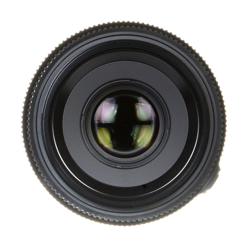 Fujinon_GF_63mm_2_8_R_WR_004 Lähikuva Fujifilm Fujinon GF 63mm f/2.8 R WR -objektiivista, jossa korostuvat sen pyöreät lasielementit ja yksityiskohtaiset harjatut reunat valkoista taustaa vasten.