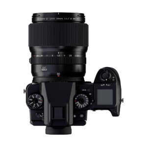 Ylhäältä katsottuna Fujifilm-kamera, johon on asennettu Fujifilm Fujinon GF 80mm f/1.7 R WR -objektiivi, jossa korostuvat säätöpyörät, painikkeet ja digitaalinen näyttö oikealla puolella.