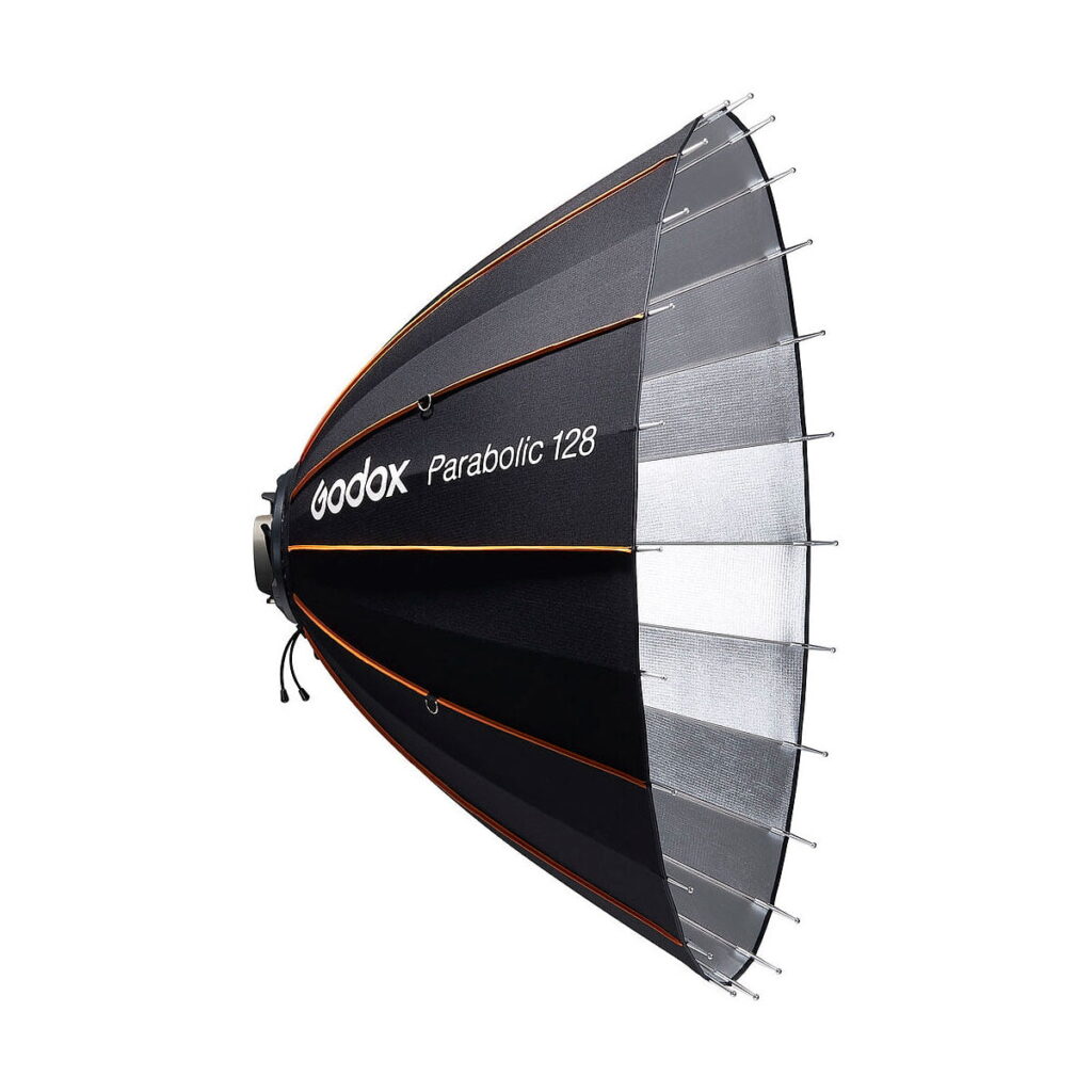 Godox_Parabolic_128_Reflector_Kit_004 Godox Parabolic 128 Reflector Kit on musta ja hopeinen parabolinen softbox oranssilla reunuksella, joka on suunniteltu valokuvauksen valaistusasetuksiin.