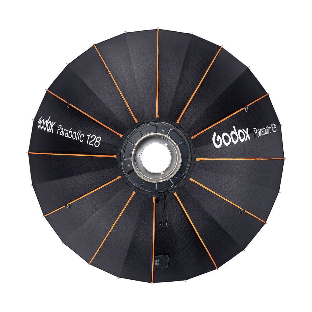 Godox_Parabolic_128_Reflector_Kit_006 Godox Parabolic 128 Reflector Kitin yläkuvassa näkyy mustia ja oransseja paneeleita, joiden kankaaseen on painettu tuotemerkki ja malli valkoisella.