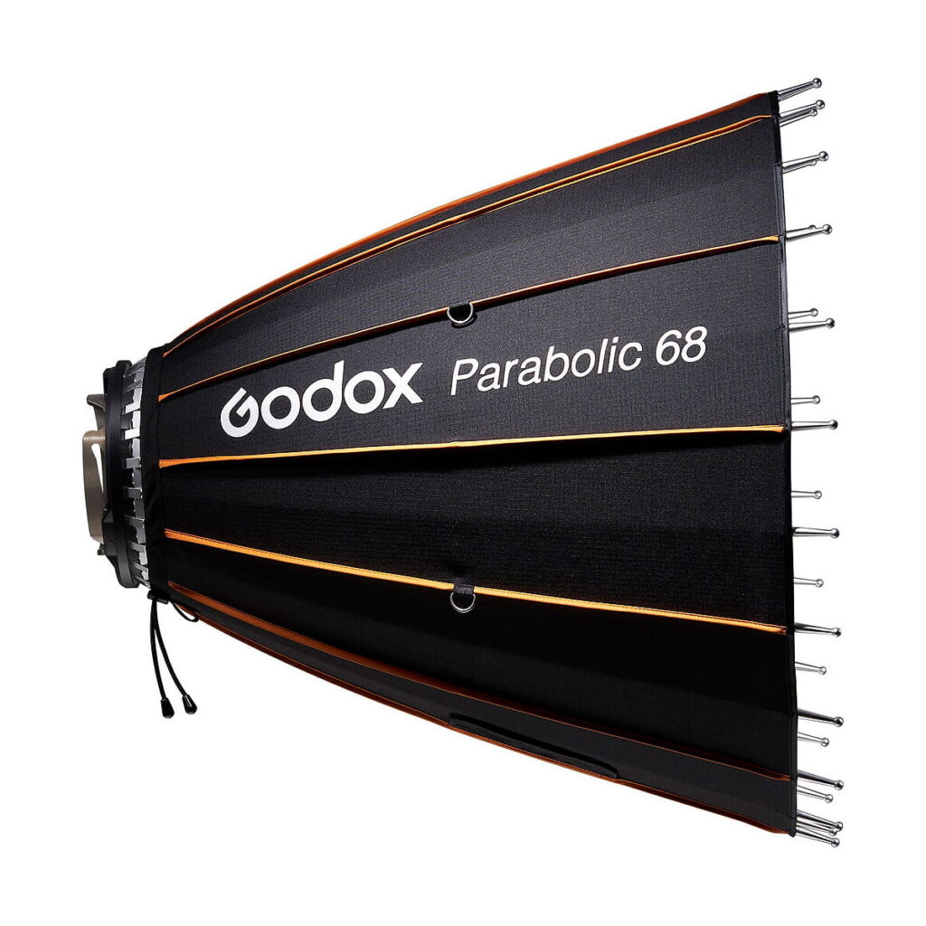 Godox_Parabolic_68_Reflector_Kit_005 Sivunäkymä mustasta Godox Parabolic 68 -heijastinsarjasta, jossa on oranssit korostukset ja hopeiset tangot valkoista taustaa vasten.