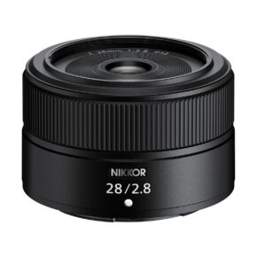 Nikon_Nikkor_Z_28mm_f_2_8_standard_001 Nikon Nikkor Z 28mm f/2.8 -objektiivi, musta, jossa on merkintä "Z 28mm 1:2.8", jossa on leveä etulasi ja harjakuvioinen tarkennusrengas ja joka on esillä valkoista taustaa vasten.