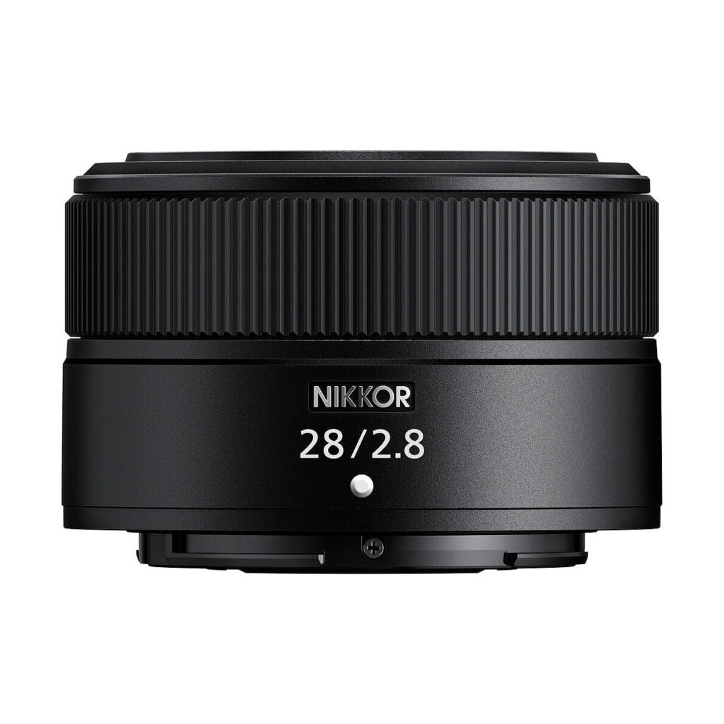 Nikon_Nikkor_Z_28mm_f_2_8_standard_002 Nikon Nikkor Z 28mm f/2.8 -objektiivi on esillä valkoisella taustalla, ja sen musta viimeistely, kuvioitu tarkennusrengas ja valkoiset kirjaimet, jotka ilmoittavat tuotemerkin ja objektiivin tekniset tiedot.