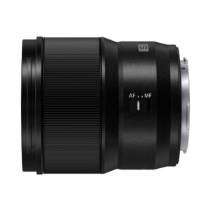 Panasonic-Lumix-S-lens-50mm-F18-01 Panasonic Lumix S-objektiivi 50mm F/1.8 -objektiivi näkyy sivulta mustana, jossa on kuvioitu tarkennusrengas, AF/MF-kytkin ja metallinen kiinnike valkoista taustaa vasten.