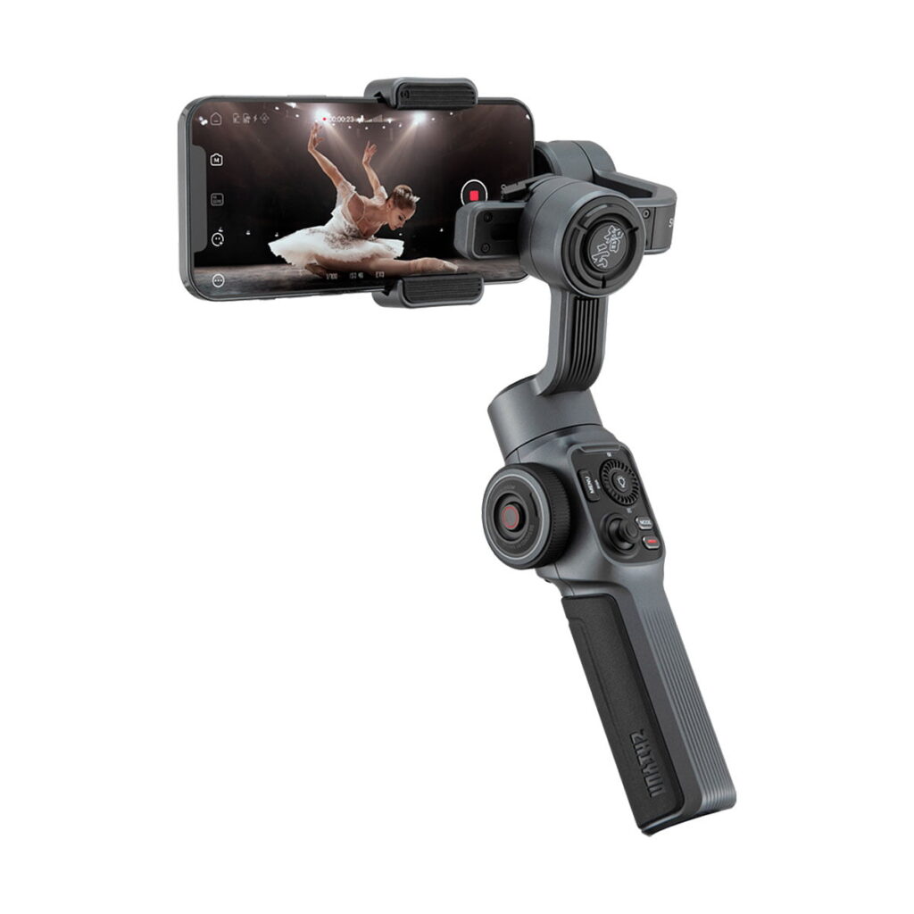 Zhiyun_Smooth_5_002 Zhiyun Smooth 5 älypuhelimille on käsikäyttöinen älypuhelimen gimbal-stabilisaattori, jossa on useita ohjauspainikkeita ja mukava ote, tässä kuvassa älypuhelin kiinnitettynä, joka tallentaa ballerinan lavalla.