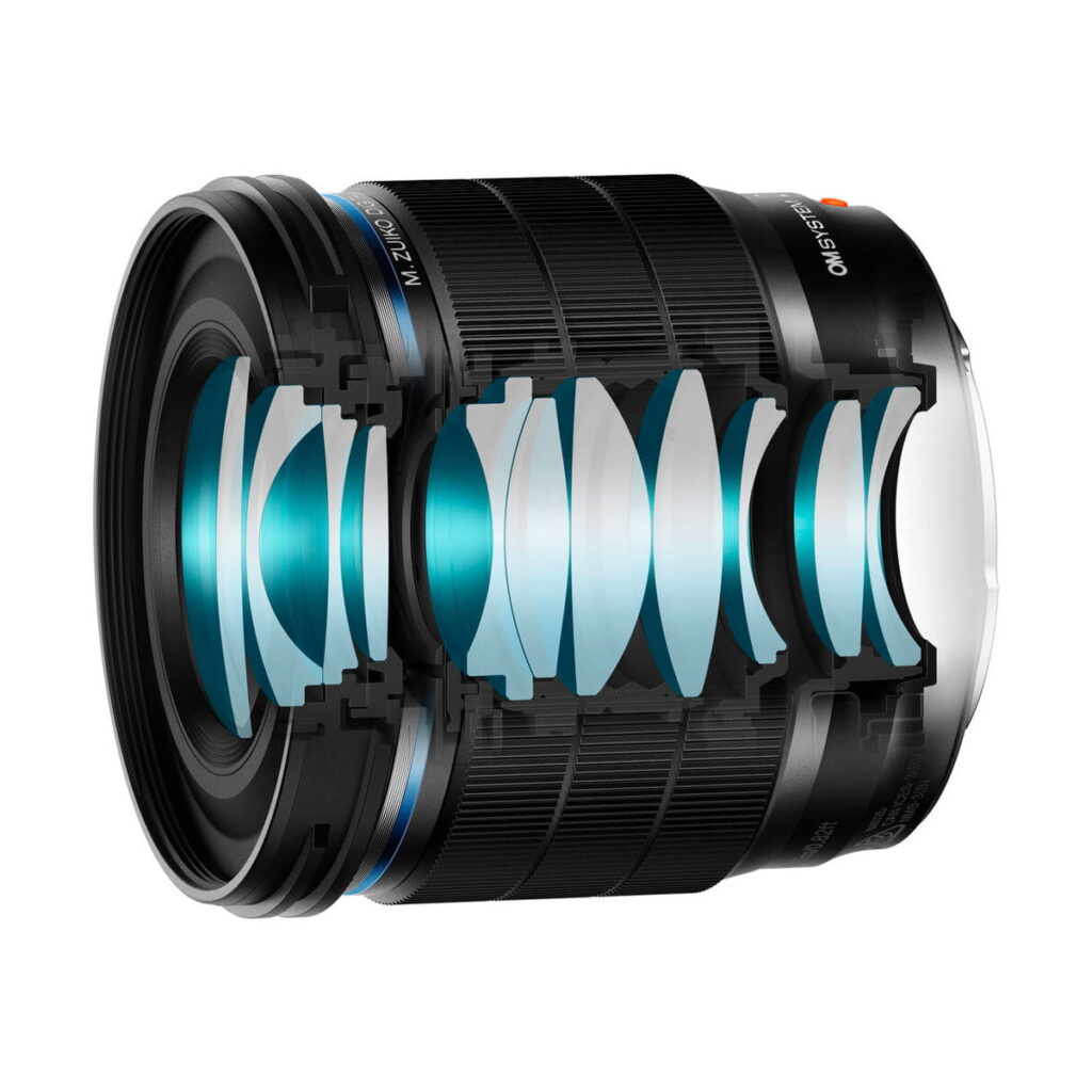 om_systems_20mm_f14_pro_02 OM SYSTEM M.Zuiko Digital ED 20mm f/1.4 PRO -objektiivin poikkileikkaus näyttää useita sisäisiä lasielementtejä sen mustassa tynnyrissä, ja jotkin osat on korostettu sinisellä optisen rakenteen havainnollistamiseksi.