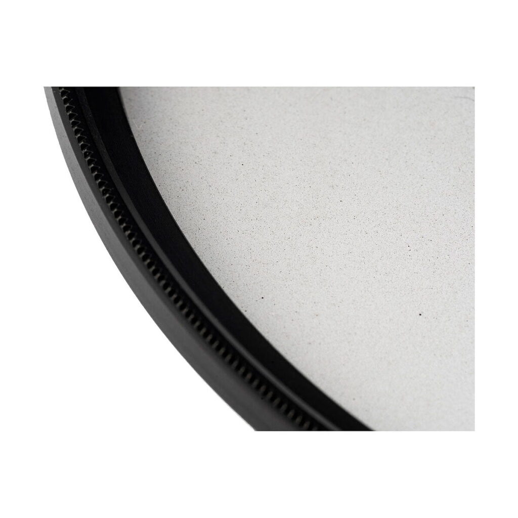 NiSi_Filter_Black_Mist_1_4_82mm_003 NiSi-suodattimen Black Mist 1/4 82mm -diffuusiosuodin reunan lähikuvassa näkyy sen pyöreä musta kehys ja sileä, vaalea pinta sisältä.