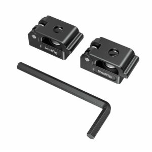 SmallRig_2418_Universal_Spring_Cable_Clamp_2_kpl_002 Kaksi mustaa SmallRig 2418 Universal Spring -jousikaapelikiinnikettä (2 kpl) näkyy mustan L-muotoisen kuusiokoloavaimen yläpuolella valkoisella pohjalla. Kummassakin puristimessa on keskireikä, urat ja siinä näkyy tuotemerkki.