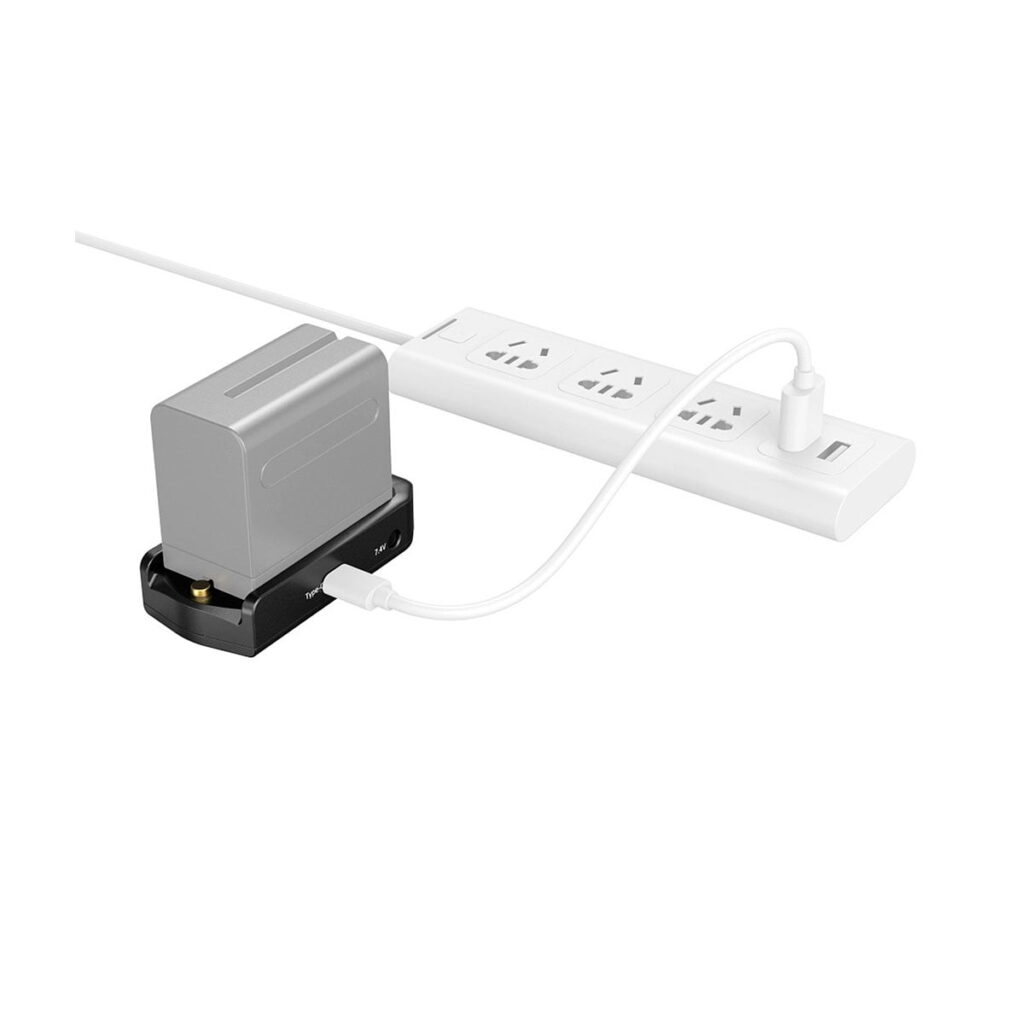 SmallRig_3168_NP-F_Battery_Adapter_Plate_Professional_Edition_004 Harmaa SmallRig 3168 NP-F -akkusovitinlevy Professional Edition latautuu mustalla telakalla, joka on liitetty valkoisella USB-kaapelilla valkoiseen monipistorasiaan.