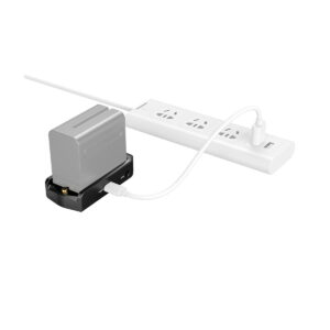 SmallRig_3168_NP-F_Battery_Adapter_Plate_Professional_Edition_004 Harmaa SmallRig 3168 NP-F -akkusovitinlevy Professional Edition latautuu mustalla telakalla, joka on liitetty valkoisella USB-kaapelilla valkoiseen monipistorasiaan.