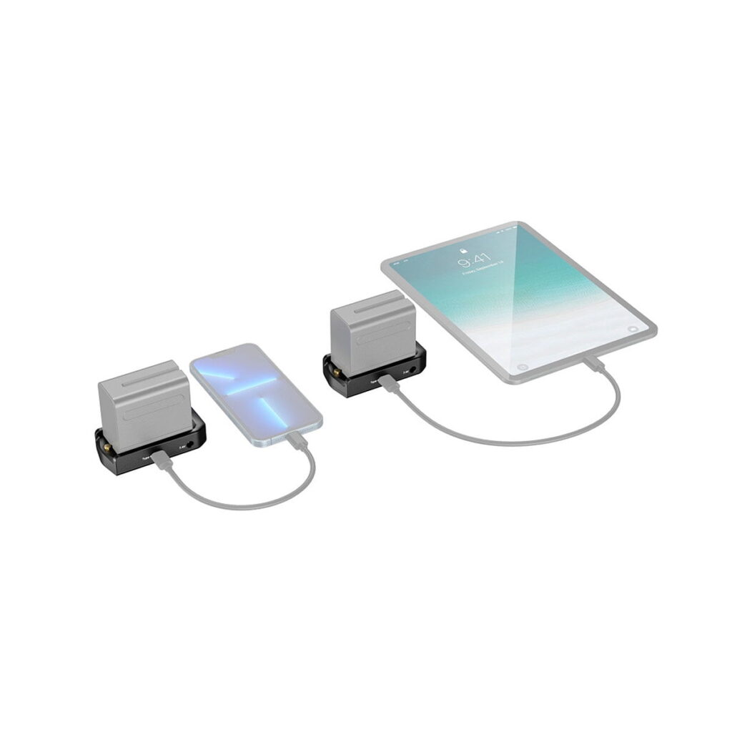 SmallRig_3168_NP-F_Battery_Adapter_Plate_Professional_Edition_006 Kaksi SmallRig 3168 NP-F Battery Adapter Plate Professional Edition -yksikköä on liitetty lyhyillä kaapeleilla älypuhelimeen ja tablettiin, jotka molemmat latautuvat valkoisella taustalla. Puhelimessa näkyy sininen salamasymboli, tabletissa 9:41.
