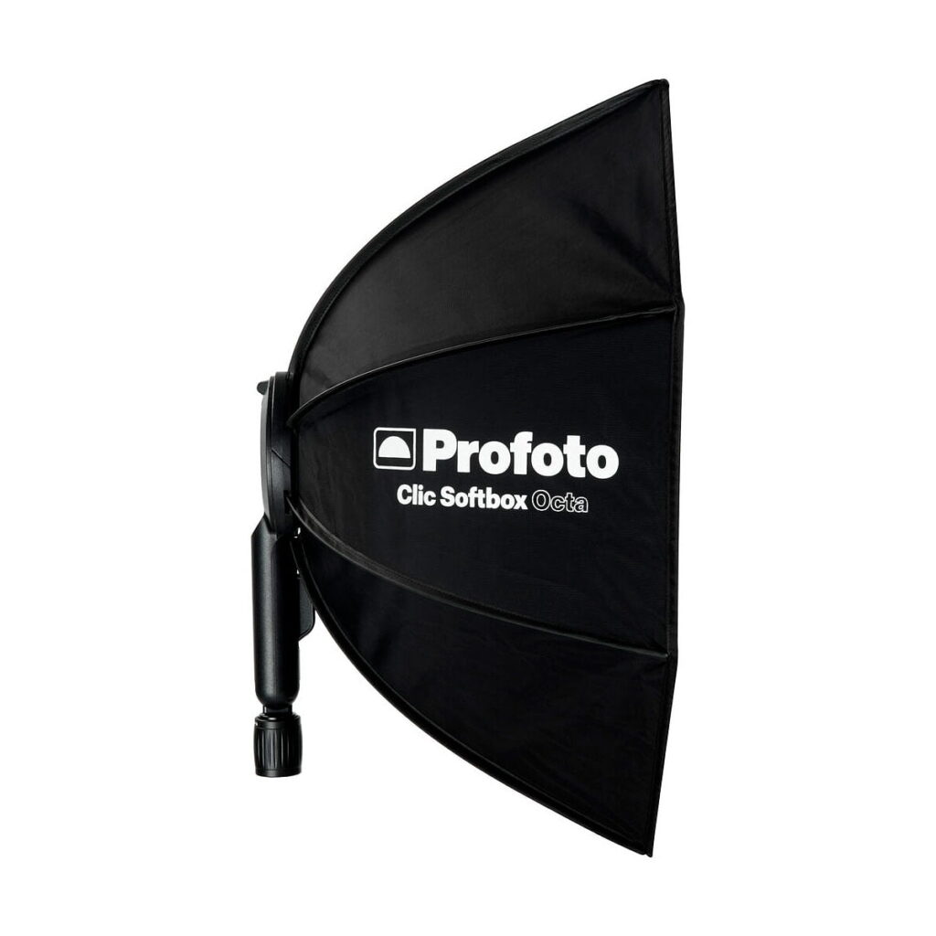 Profoto_Click_Softbox_Octa_003 Musta Profoto Click Softbox Octa on esillä sivuttain valkoisella pohjalla, ja sen valkoinen logo ja tuotenimi ovat pehmeässä, pyöreässä kahdeksankulmaisessa etupaneelissa.
