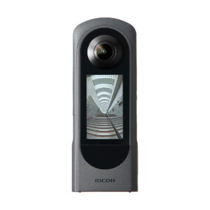 Ricoh_Theta_X_002 Ricoh Theta X 360 asteen kamerassa on pyöreä linssi ylhäällä ja näyttö alhaalla, ja se tallentaa kuvia kuin moderni portaikko, jossa on geometrisia linjoja.