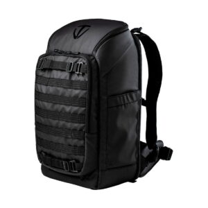 Tenba_Axis_24L_Tactical_Backpack_001 Tenba Axis 24L Tactical Backpack on tyylikäs musta laukku, jossa on useita vaakasuoria etuhihnoja, yläkahva ja pehmustetut säädettävät olkahihnat valkoista taustaa vasten.