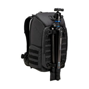 Tenba_Axis_24L_Tactical_Backpack_007 Mustassa Tenba Axis 24L Tactical Backpack -repussa, jossa on pehmustetut hihnat ja MOLLE-hihnat, on esillä musta ja sininen kameran jalusta, joka on kiinnitetty turvallisesti sen etuosaan säädettävillä hihnoilla.