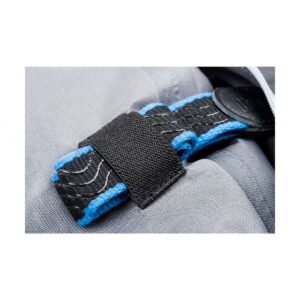 Think_Tank_Photo_Hydrophobia_D_24-70_V3_010 Close-up of Think Tank Hydrophobia D 24-70 V3 with blue and black fabric strap with white stitches attached with black Velcro on a light grey fabric surface.