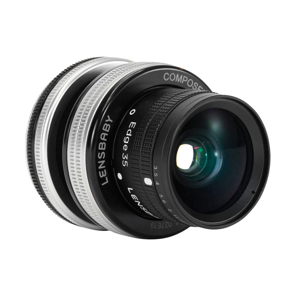 Lensbaby_Composer_Pro_II_Edge_35-Sony_E_003 Lähikuva Lensbaby Composer Pro II + Edge 35 - Sony E -kameran objektiivista, jossa korostuvat yksityiskohtaiset tarkennus- ja aukkomerkinnät sen tyylikkäässä mustan ja hopeanvärisessä lieriömäisessä rungossa.