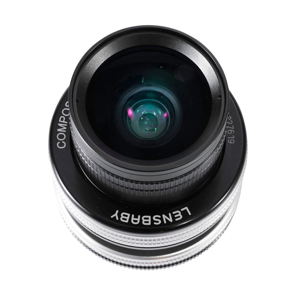 Lensbaby_Composer_Pro_II_Edge_35-Sony_E_004 Lensbaby Composer Pro II + Edge 35 for Sony E -objektiivin lähikuvassa, joka on kuvattu ylhäältä valkoisella taustalla, korostuvat objektiivin lasielementit ja yksityiskohtaiset renkaat.