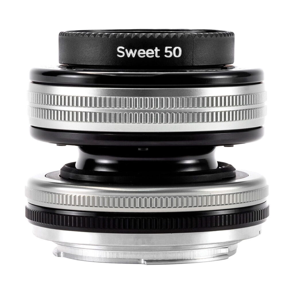 Lähikuva Lensbaby Composer Pro II + Sweet 50 Sony E:lle -objektiivista, jossa näkyy sen kompakti, pyöreä muotoilu, hopeiset ja mustat metallirenkaat sekä kuvioidut tartuntapinnat.