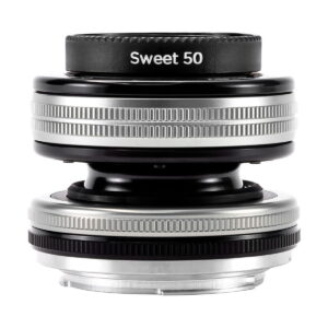 Lähikuva Lensbaby Composer Pro II + Sweet 50 Sony E:lle -objektiivista, jossa näkyy sen kompakti, pyöreä muotoilu, hopeiset ja mustat metallirenkaat sekä kuvioidut tartuntapinnat.