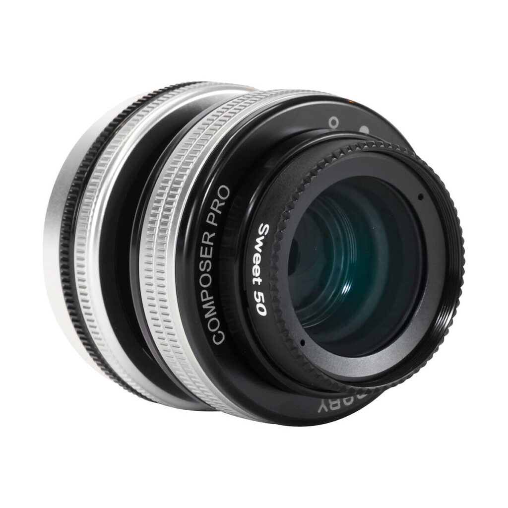 Lähikuva Lensbaby Composer Pro II + Sweet 50 Sony E:lle, jossa näkyy sen hopeanmusta tynnyrimuotoilu "Composer Pro II" ja "Sweet 50" -merkinnöillä ja kirkkailla lasielementeillä.