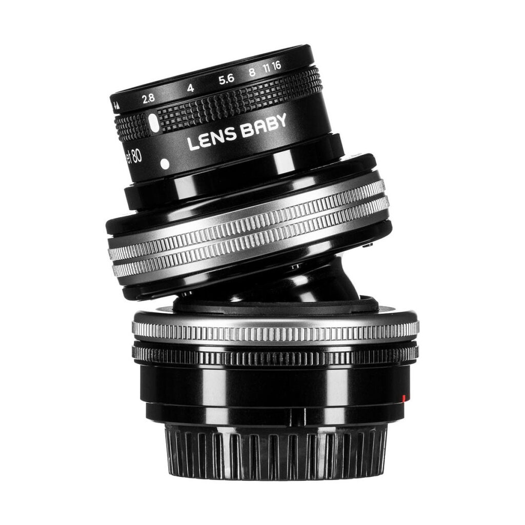 Lensbaby_Composer_Pro_II_Sweet_80-Sony_E_005 Lensbaby Composer Pro II + Sweet 80 Sony E:lle on kuvassa mustana hopeisilla korostuksilla, kallistettuna valkoisella taustalla. Kameran objektiivin aukko- ja tarkennusrenkaat näkyvät selvästi.
