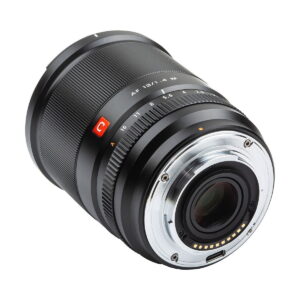 Viltrox_AF_13mm_f_1_4_Fuji_X_004 Lähikuva Viltrox AF 13mm f/1.4 -objektiivi, Fuji X näyttää sen mustan linssin, metallisen kiinnikkeen, elektroniset koskettimet ja merkityt aukko- ja tarkennusrenkaat valkoista taustaa vasten.